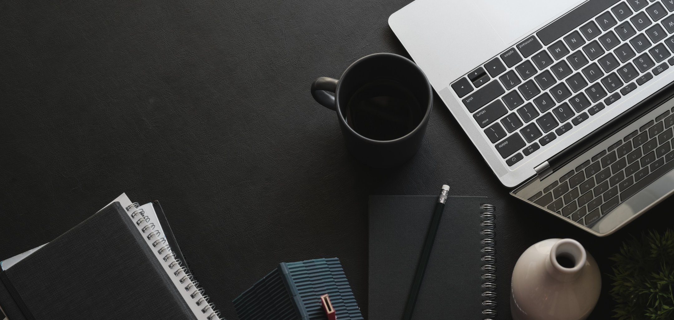 Elegant dark desk with laptop and notepads